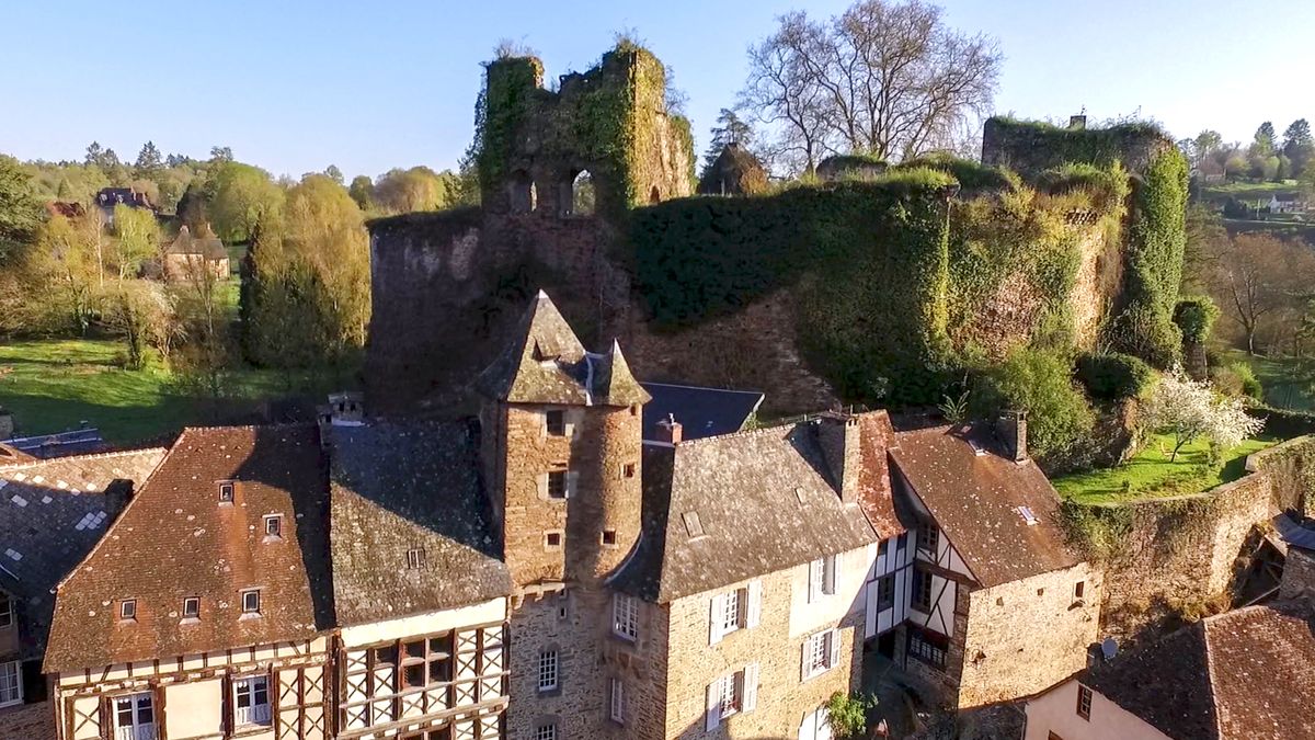 Vue aérienne des vestiges du château de Ségur avec des maisons au premier plan © Région Nouvelle-Aquitaine, Dragonfly