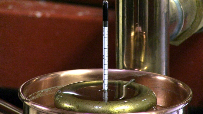 A la sortie du serpentin, le porte-alcoomètre sert de support aux équipements de mesure, thermomètre et alcoomètre ; c'est là qu'ont lieu la séparation et les prélèvements des fractions de distillat.