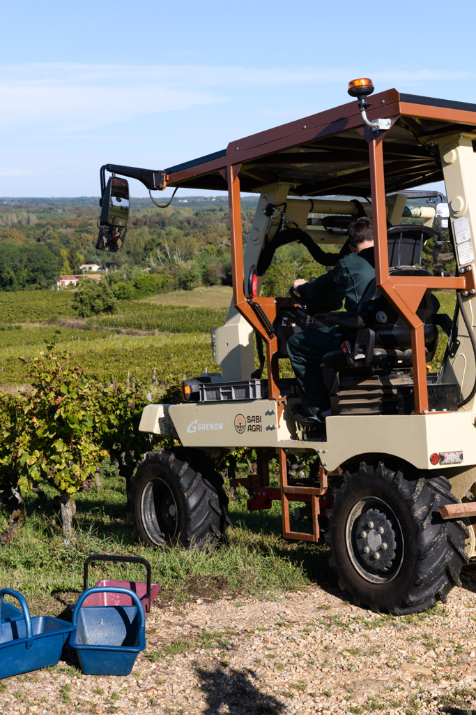 Lycéen conduisant un tracteur dans les vignes.