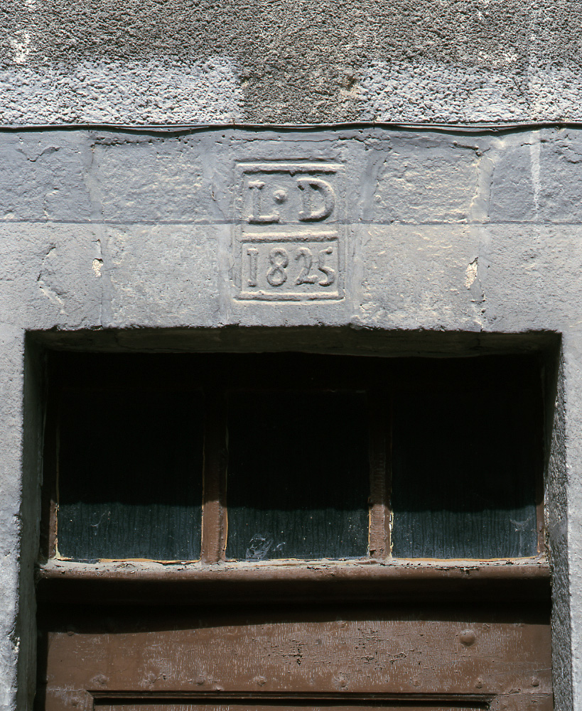 Détail du cartouche portant l'inscription L.D et la date de 1825, sur le linteau de la porte d'entrée du numéro 61.