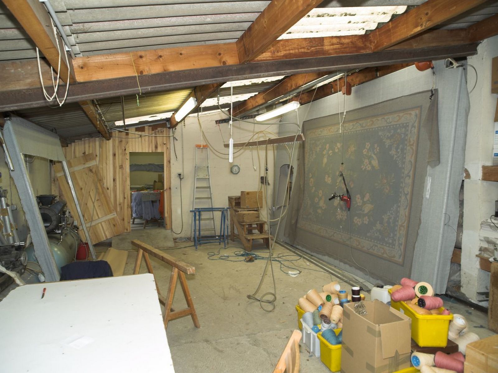 Vue intérieure de l'appentis contenant l'atelier de tissage au point piqué main et le séchoir.