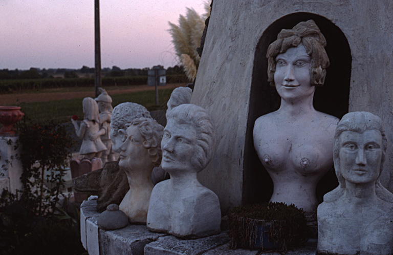 Bustes situés sur la margelle du moulin, photographiés en 1977.