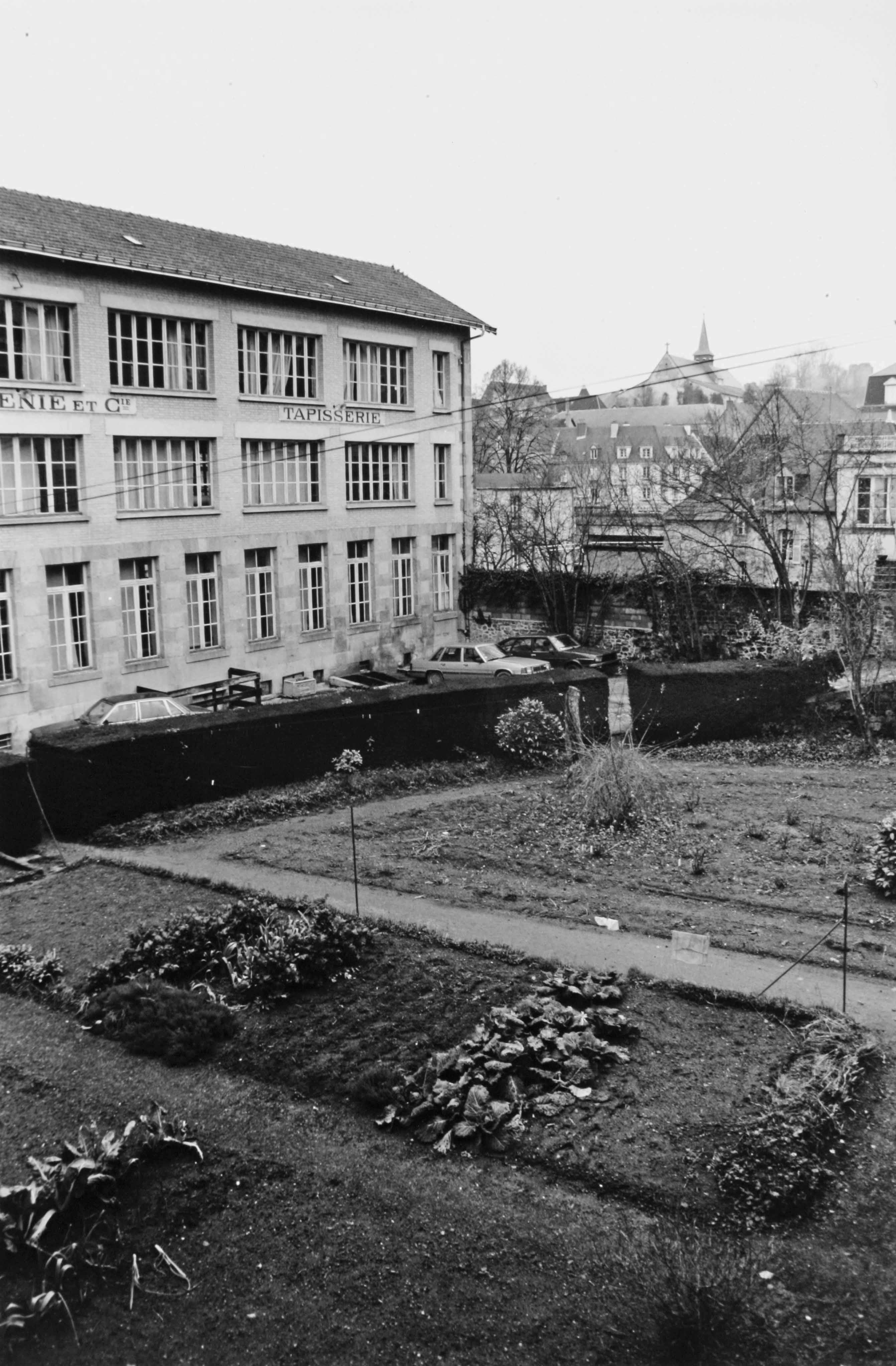Le bâtiment des ateliers de tissage (élévation sud) et les jardins de la manufacture (reportage photographique de L. Yeghicheyan, 1992, Aubusson, Musée départemental de la Tapisserie)