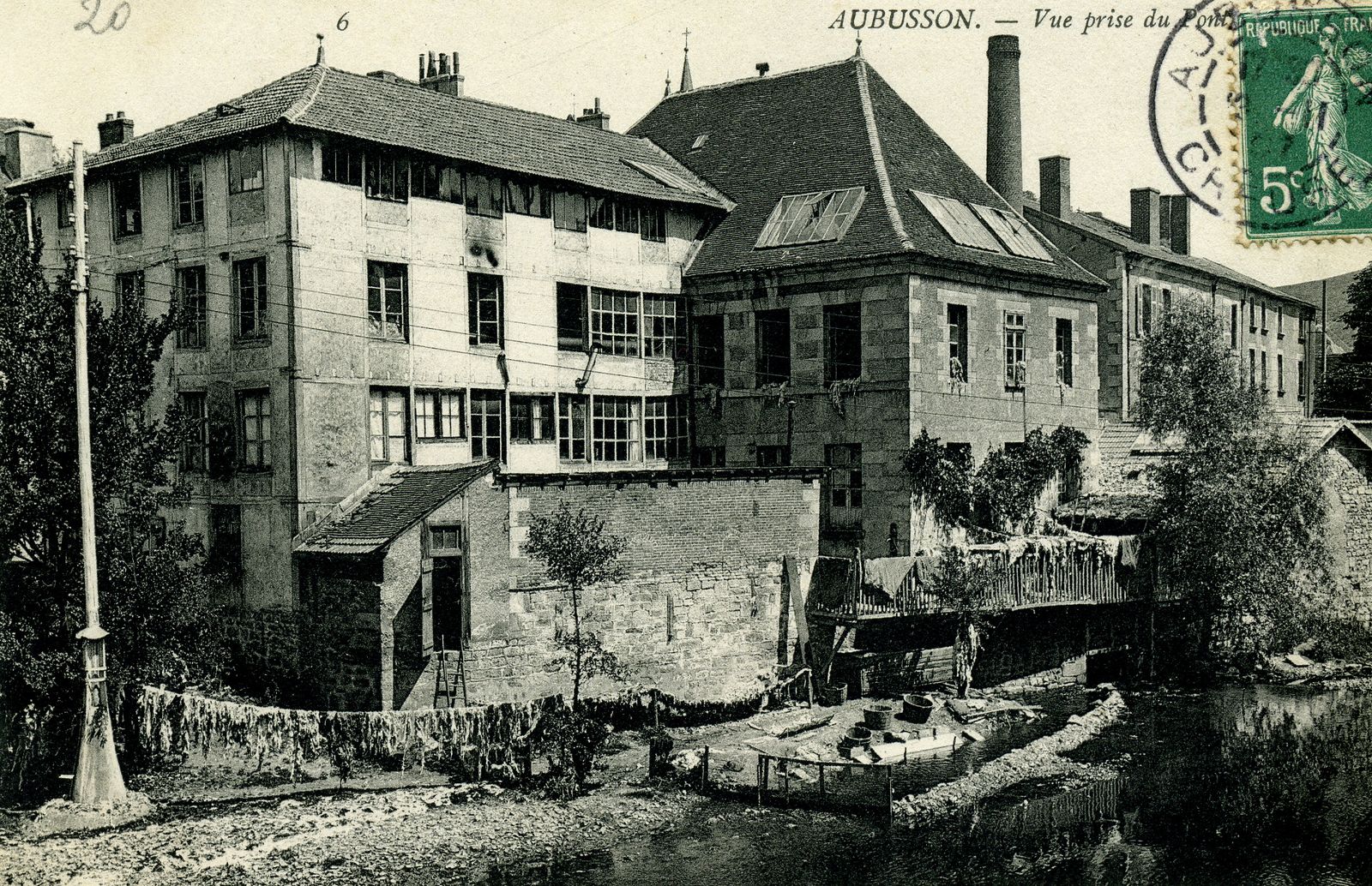 Carte postale de la manufacture Danton, dans le 1er quart du 20e siècle, vue depuis le pont Neuf, en direction de la rue des Tanneurs (AD 23)
