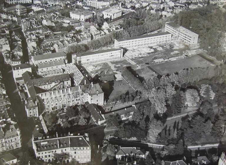 Vue aérienne du lycée en 1955 avec les extensions à l'est et les bâtiments anciens à l'ouest encore présents.