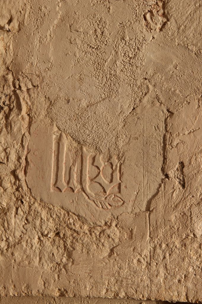 Monogramme IHS sculpté au-dessus de l'armoire eucharistique sur le mur sud du choeur.