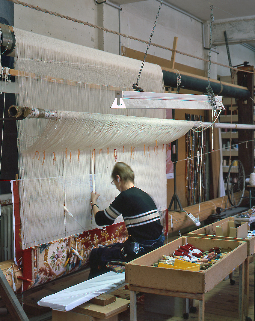 Détail du tissage d'un tapis Savonnerie au point noué, sur un métier de haute lisse.