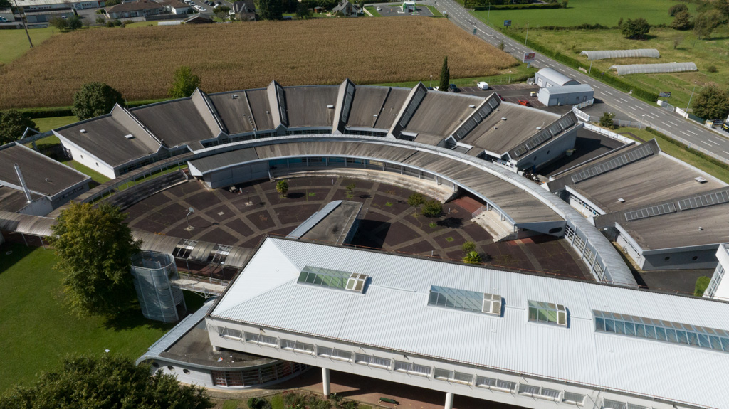 Vue aérienne des ateliers en arc de cercle et une partie du bâtiment administratif.