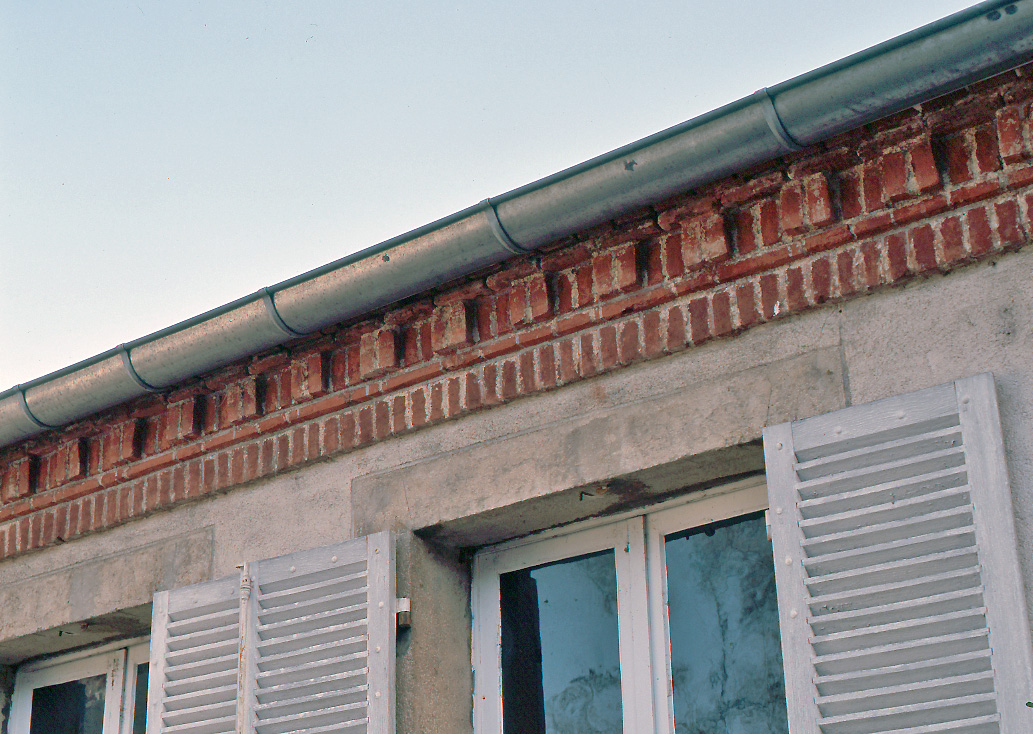 Détail de la frise en brique agrémentant le sommet du mur-gouttereau du bâtiment des bureaux de la manufacture