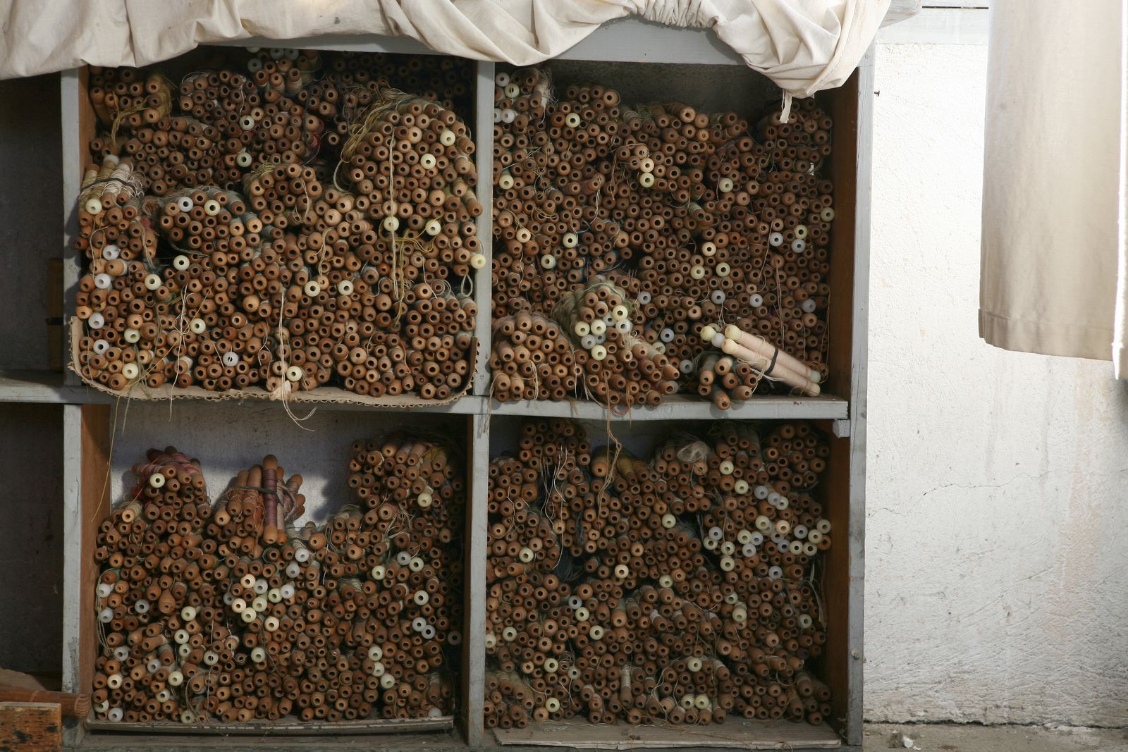 Détail des casiers contenant les flûtes, dans le magasin des laines.