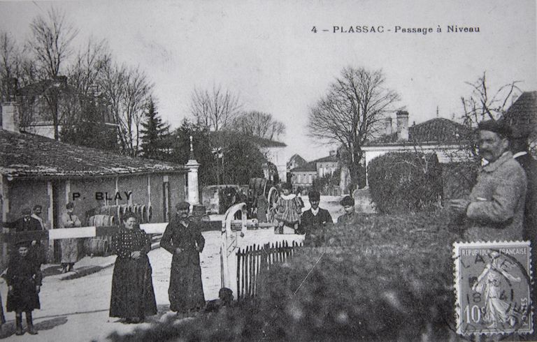 Carte postale : passage à niveau dans le bourg, vers 1900.