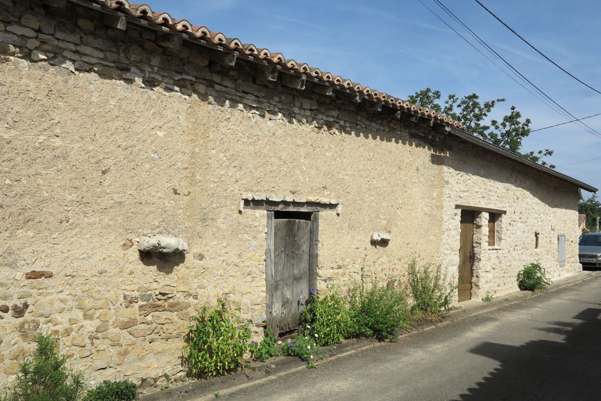 Grange à Mortioux, porte d'accès à l'étable, à encadrement en bois et linteau protégé par un larmier en pierre. Elle est encadrée d'anneaux à attacher les animaux.