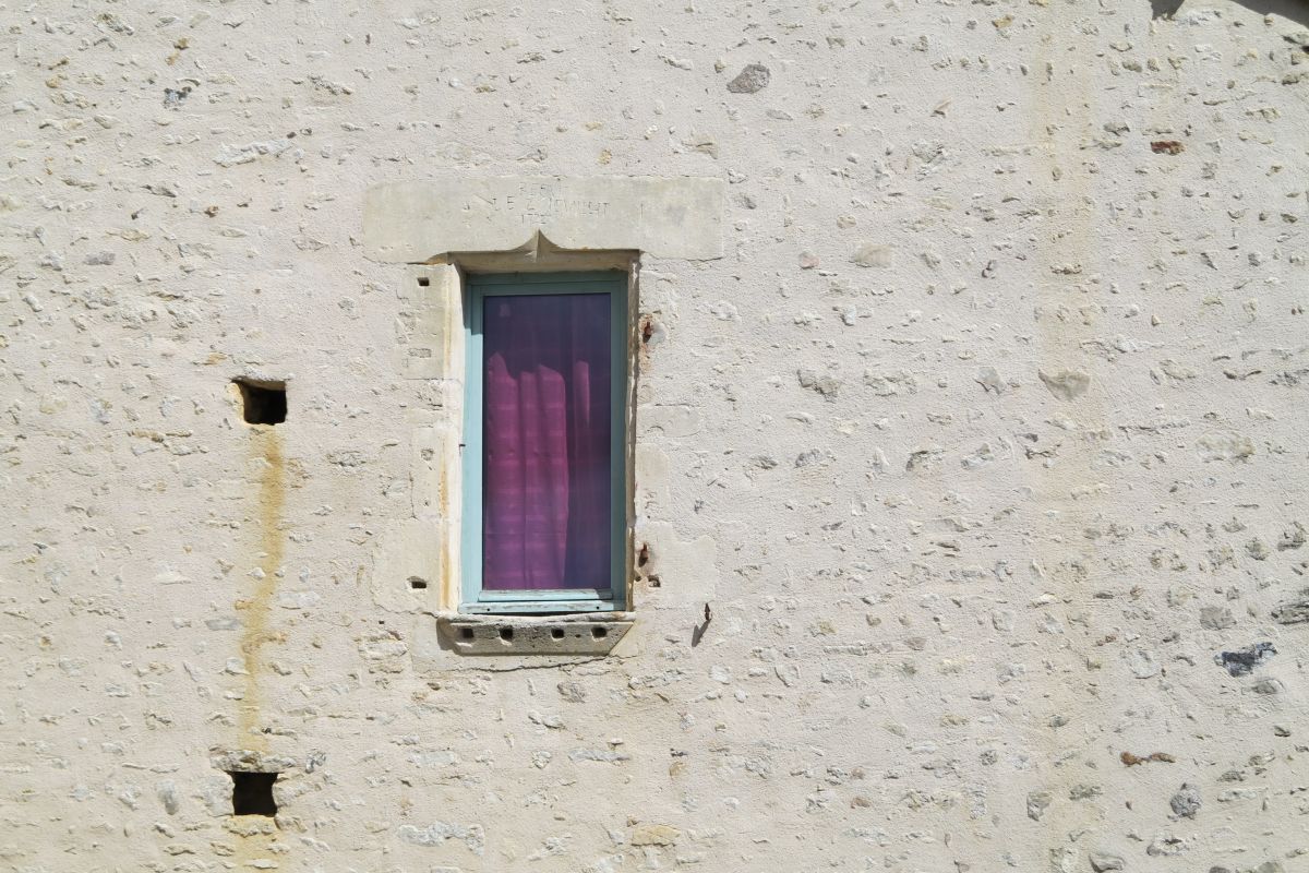 Fenêtre à appui mouluré et linteau en accolade portant l'inscription « Refait le 2 JEUILLIT [Juillet] 1732 », sur la façade d'une maison située 12 rue du Vieux-Puits.