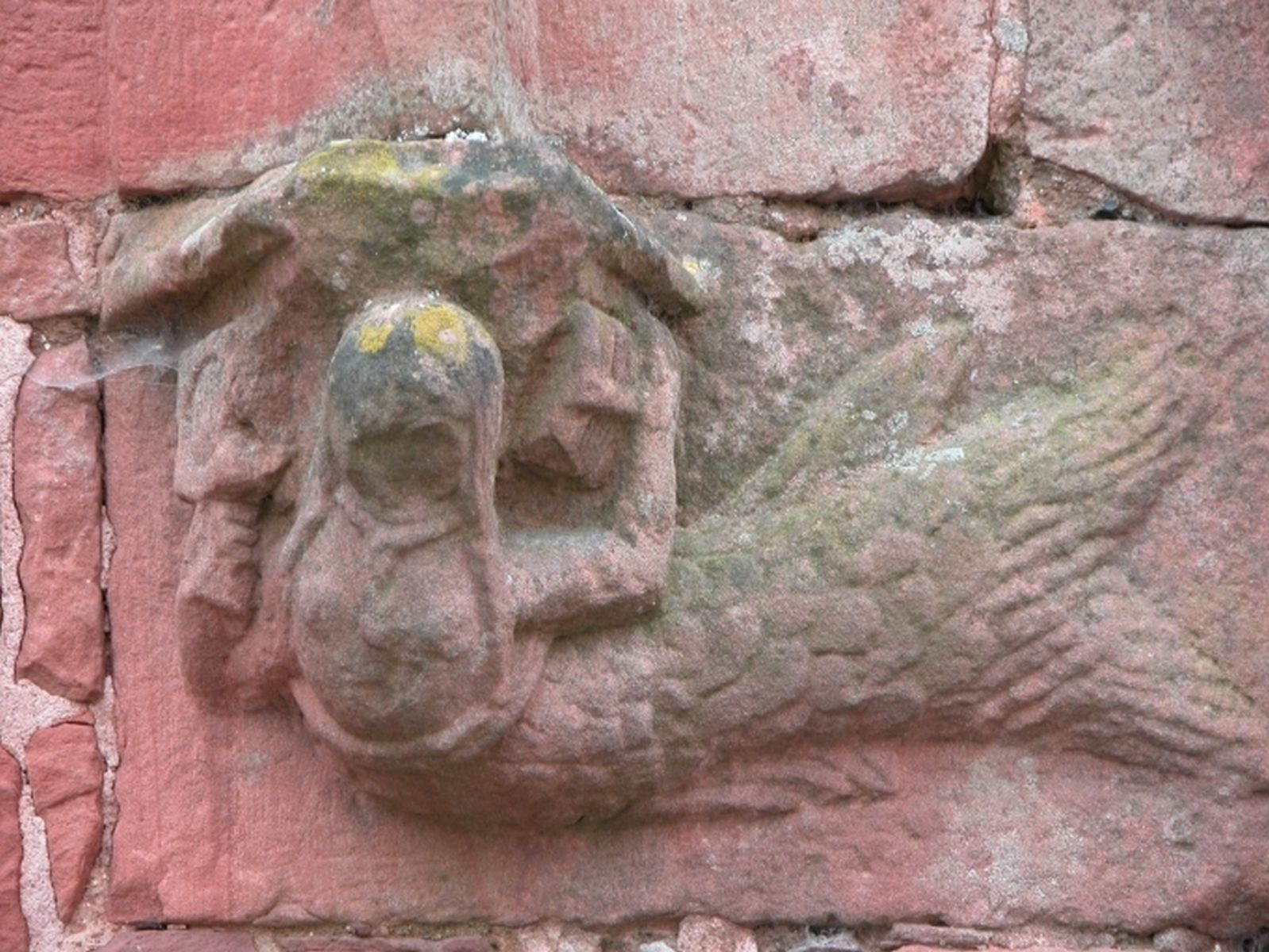 Sculpture en grès rouge, située à droite de la porte d'entrée, représentant une sirène.