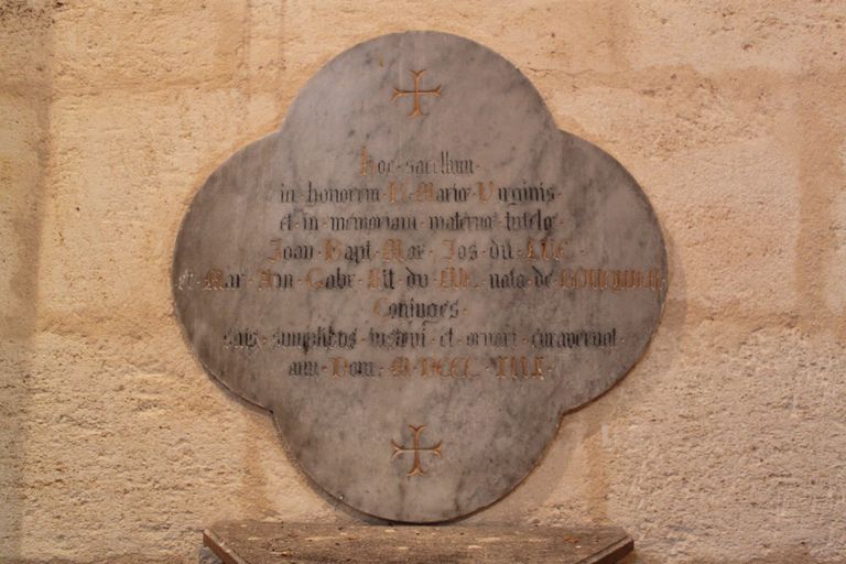 Transept, bras nord : plaque commémorative quadrilobée.