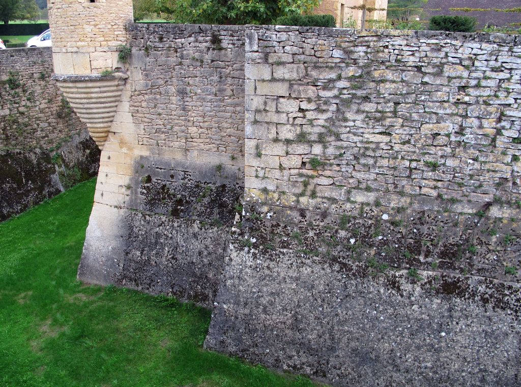 Détail du mur d'escarpe sud de la plate-forme du château : rocher taillé et assises en pierre de taille surmontées d'une maçonnerie plus récente.