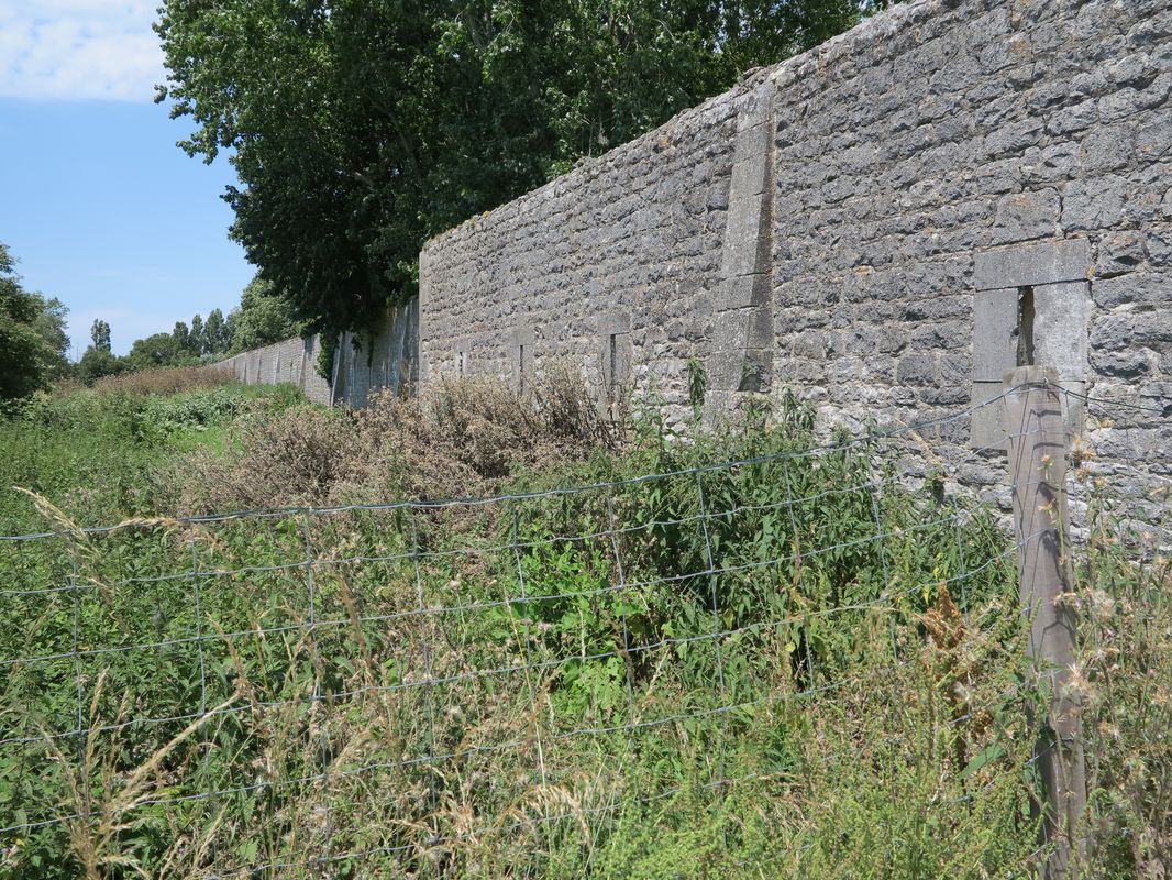 Le mur édifié au sud du bassin en 1890 vu de l'extérieur de l'arsenal. 