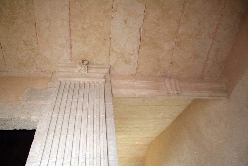 Grand corps de logis, aile sud : vue de la partie haute du mur noyau, à pilastre dorique, et du plafond plat en pierre couvrant le couloir et le palier.