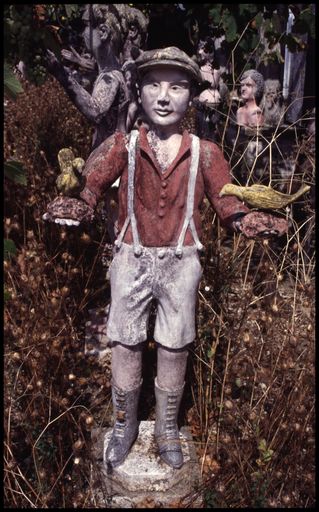 Statue de jeune homme portant deux oiseaux, photographiée en 1999, aujourd'hui disparue.