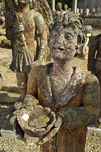 Statue située près de la sortie avec une sébile contenant de la monnaie.