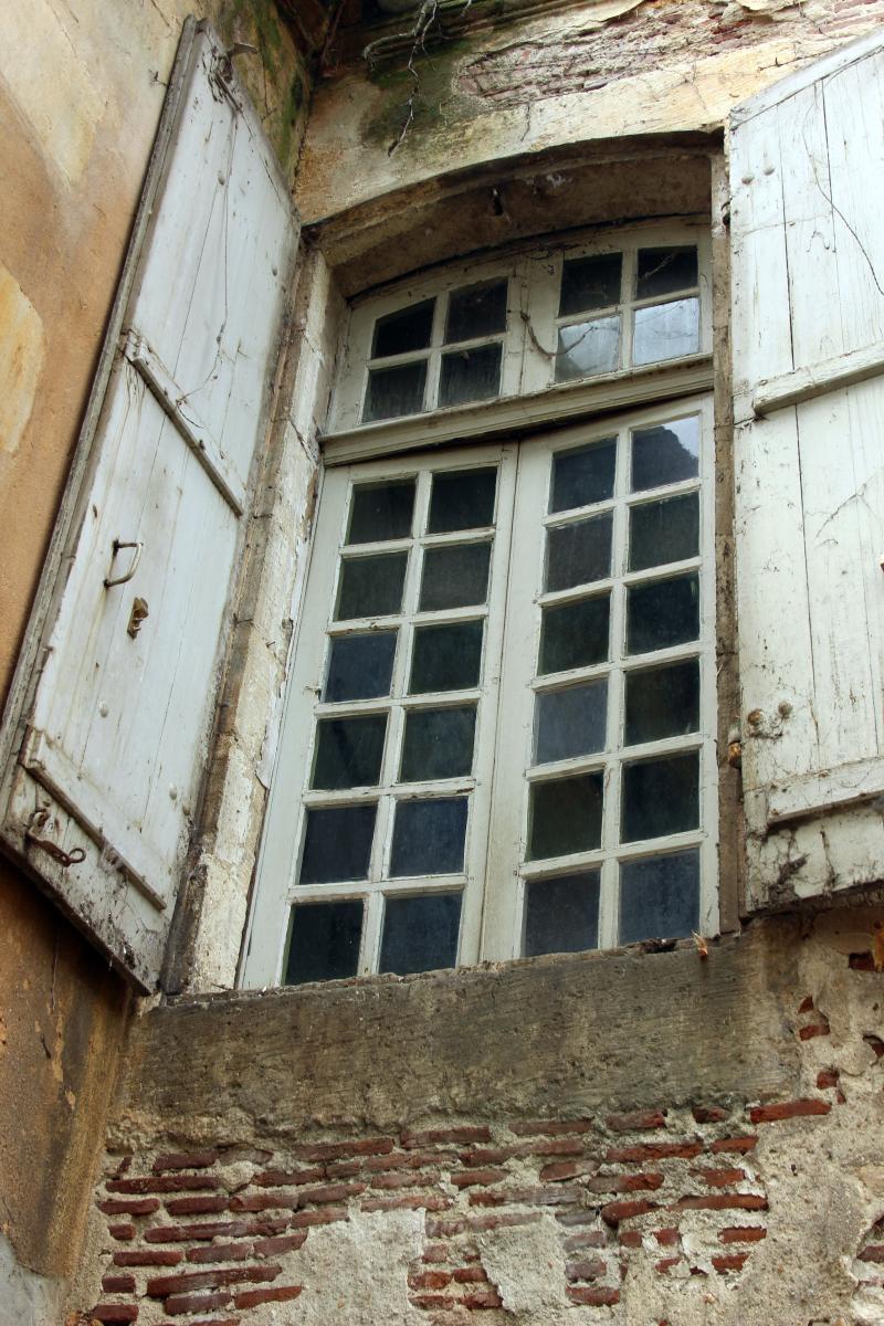Détail de la façade sur jardin, première travée : fenêtre du rez-de-chaussée surélevé, volets ouverts, avec carreaux à petits bois.