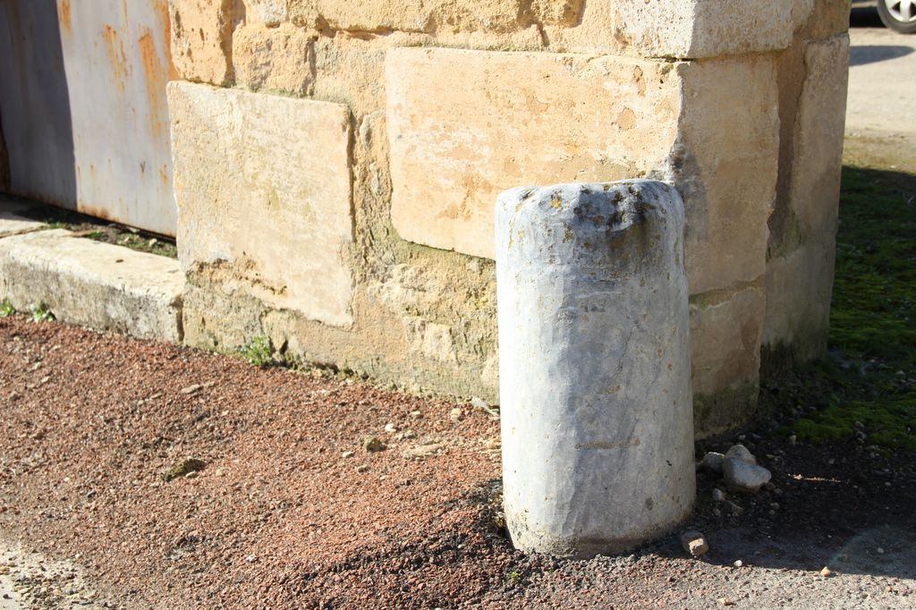Portail d'entrée du domaine : chasse-roue constitué d'un remploi de fut de colonne en marbre.