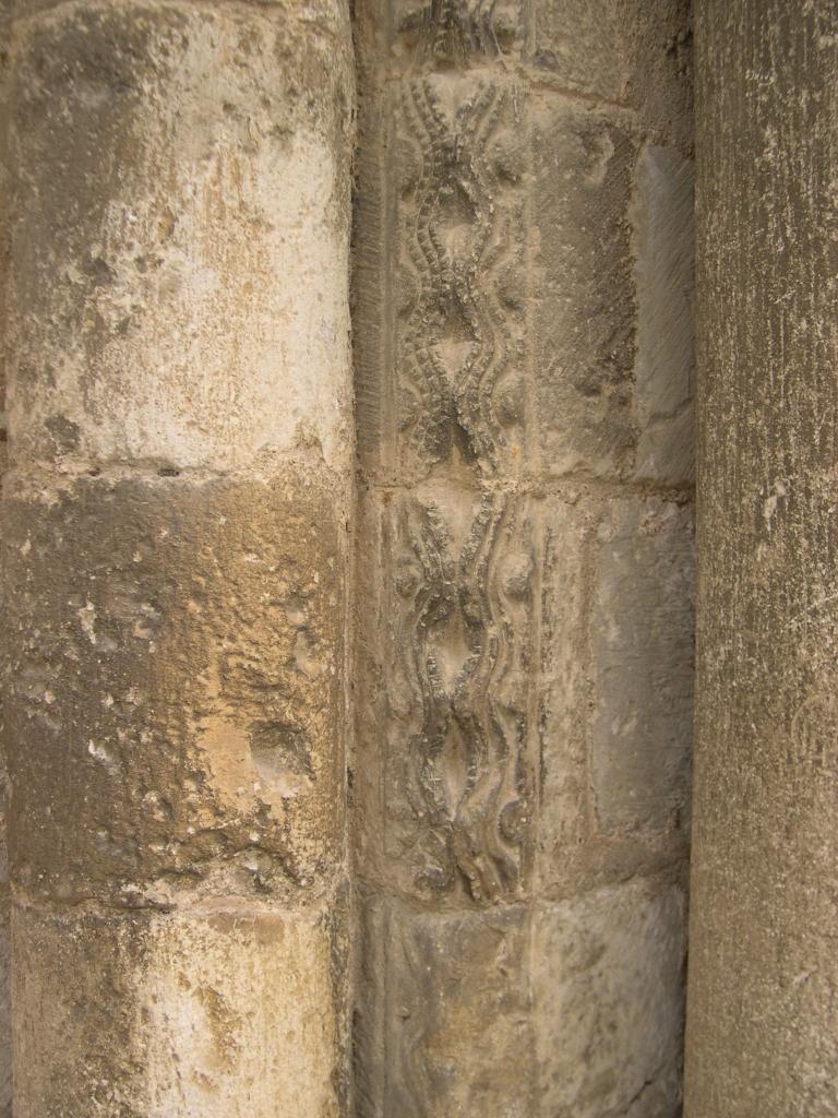 Façade occidentale, premier niveau, arcature nord, piédroit droit, arête entre les colonnettes externe et centrale : vaguelettes et boules.