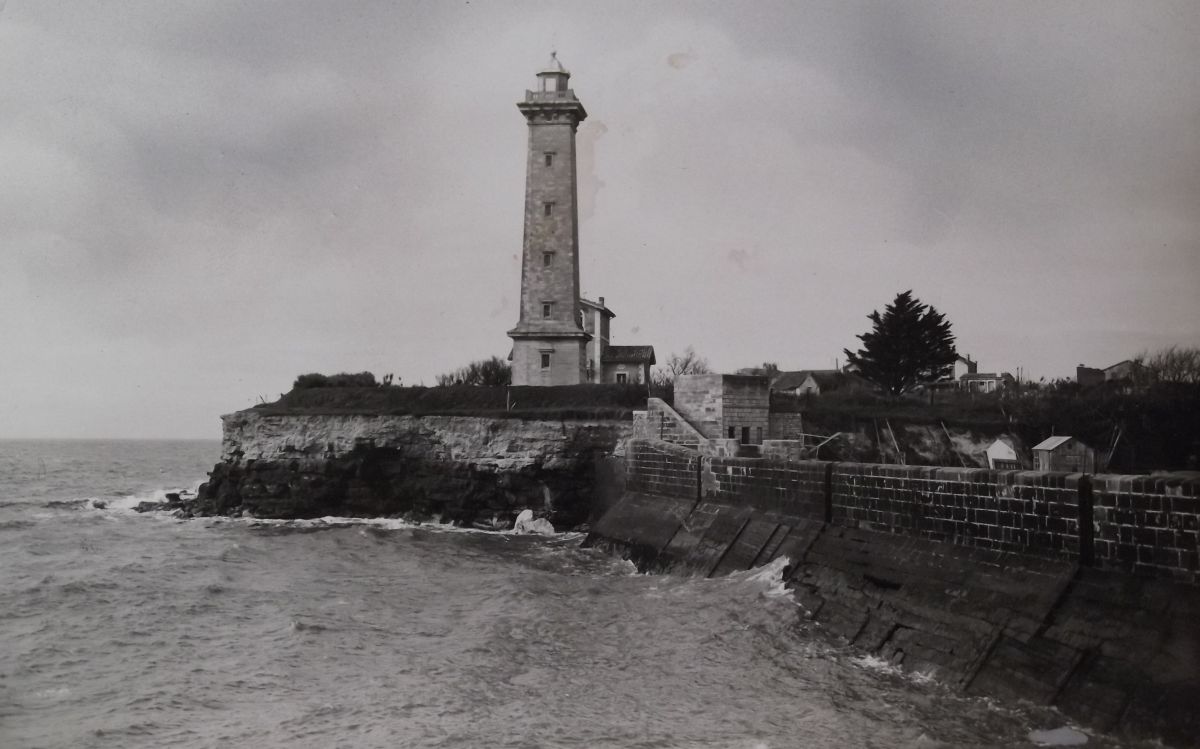 Le phare et l'ancienne maison-phare vus depuis la jetée du port vers 1930.