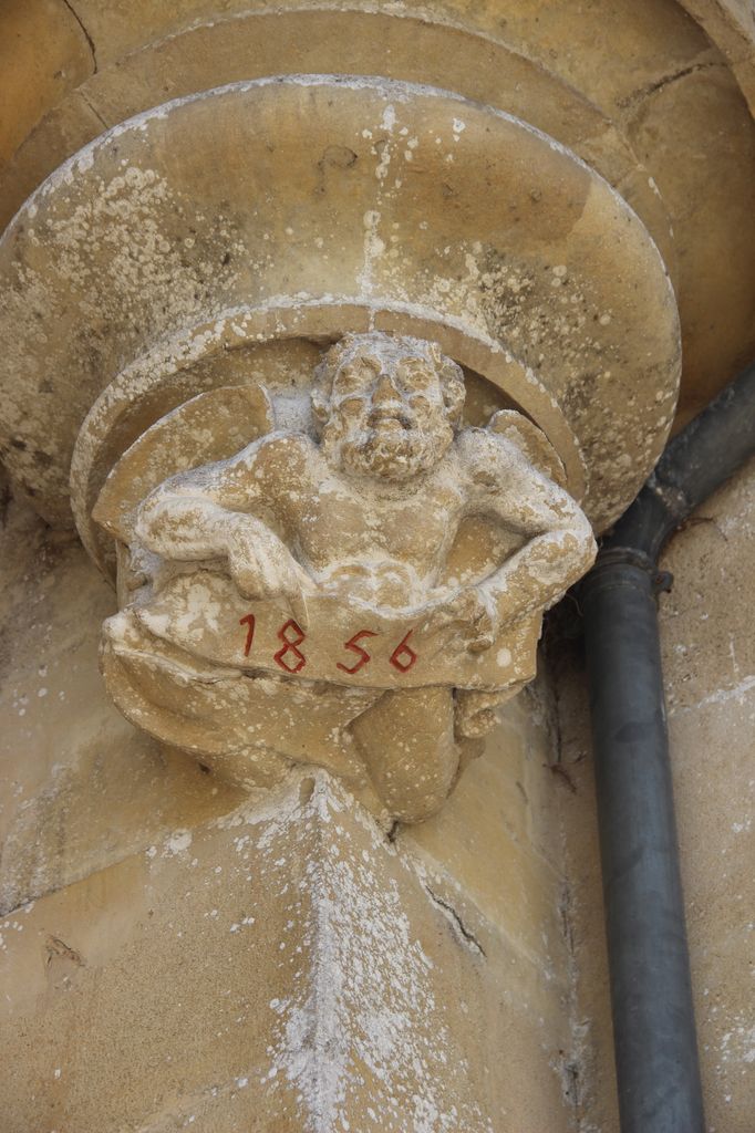 Façade est : tourelle à l'angle de l'avant-corps et de la partie droite du corps de logis : détail du personnage sculpté et de la date sur le cul-de-lampe.