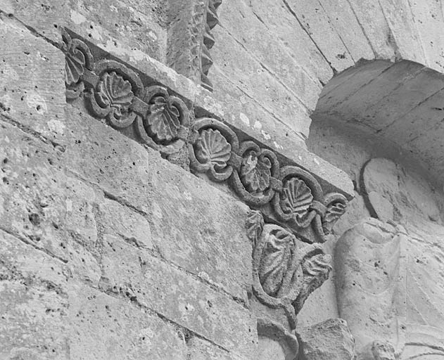 Elévation sud, troisième travée, niche au-dessus du portail, détail de la retombée gauche de l'arc : rinceaux de feuillage.