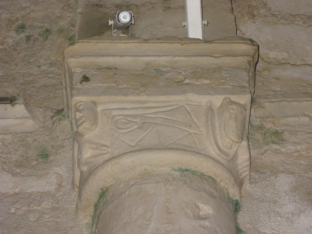 Détail d'un chapiteau de la nef : personnage et animal séparé par un motif en forme de zigzag et de crosse.