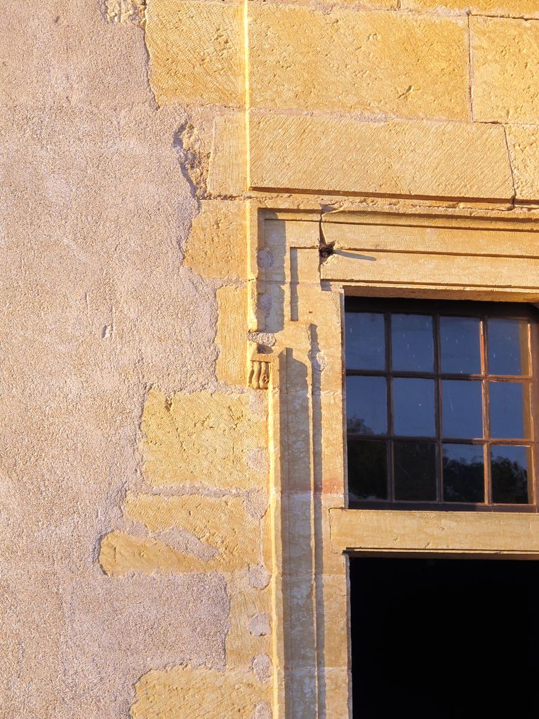 Grand corps de logis, aile sud, élévation côté jardin (sud) : fenêtre du rez-de-chaussée éclairant la pièce voûtée, détail de la crossette supérieure gauche du chambranle à petite console pendante.