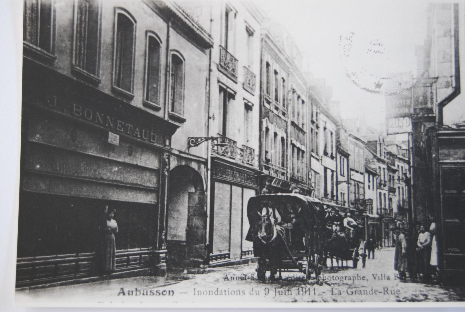 Carte postale (AD 23) montrant la Grande Rue lors des inondations de 1911, avec son bâti dense et serré. 