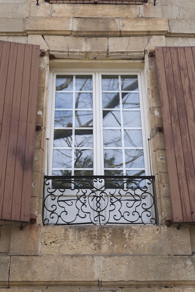 Maison du XIXe siècle de Montignac : détail de la fenêtre à balconnet du premier étage, munie d'un garde-corps en fer à entrelacs et caducée.