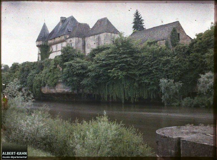 Le château de Losse vu au nord-est depuis la rive gauche de la Vézère, l'écluse de Losse au premier plan à droite, photographie autochrome, 13 juin 1916 (Musée départemental Albert-Kahn, A008883).