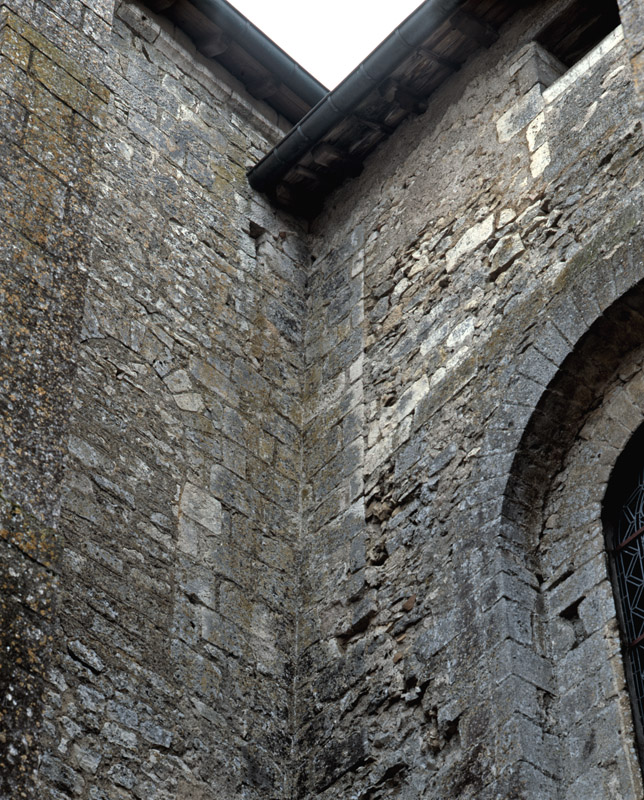 Église, côté nord, collage entre le mur ouest du bras de transept et le mur de la nef. Baie murée.