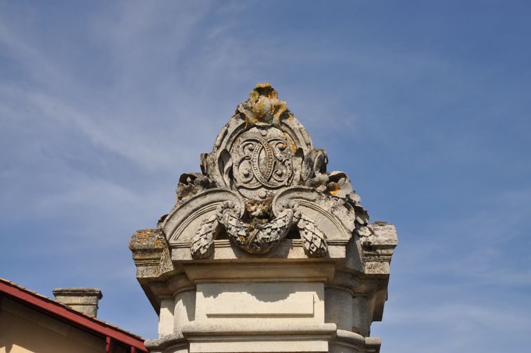 Pilier du portail nord-est : décor sculpté avec initiales E, S et C (Edouard et Suzanne Cruse).