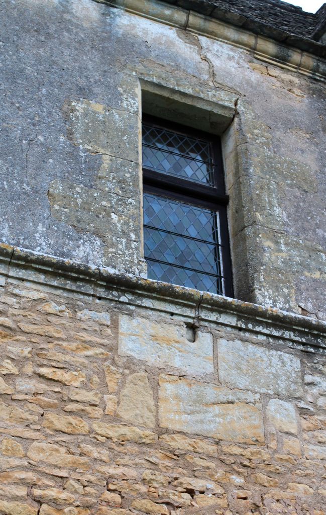 Pavillon de jardin. Détail de la face sud : fenêtre du rez-de-chaussée surélevé avec l'allège percée d'un orifice de tir circulaire.