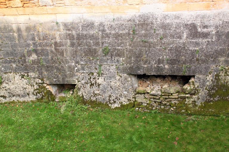 Enceinte du château : détail de la partie inférieure du mur d'escarpe posé sur le rocher vu à l'ouest..