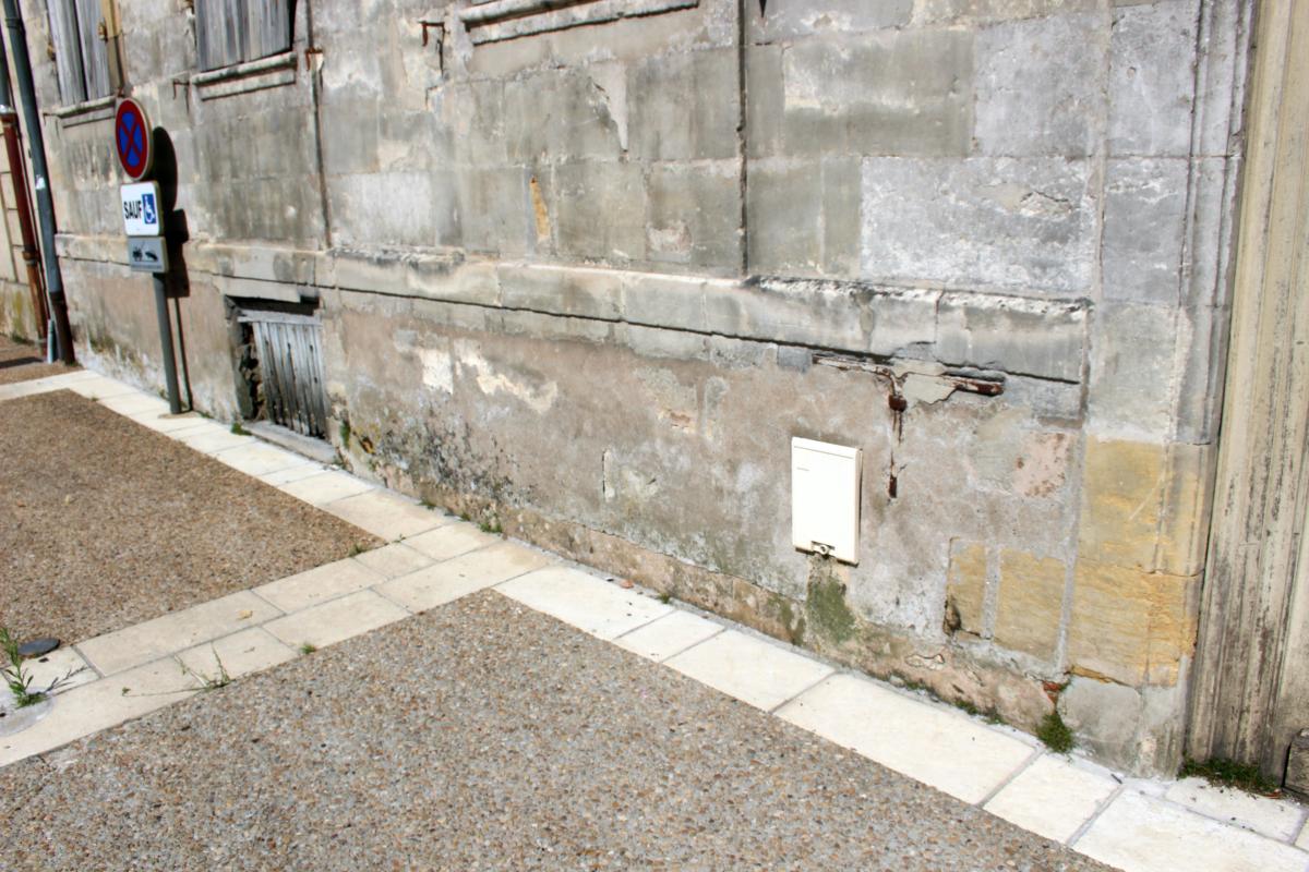 Détail du soubassement de la façade sur rue (ouest) : ancre métallique correspondant à l'une des poutres de plancher.