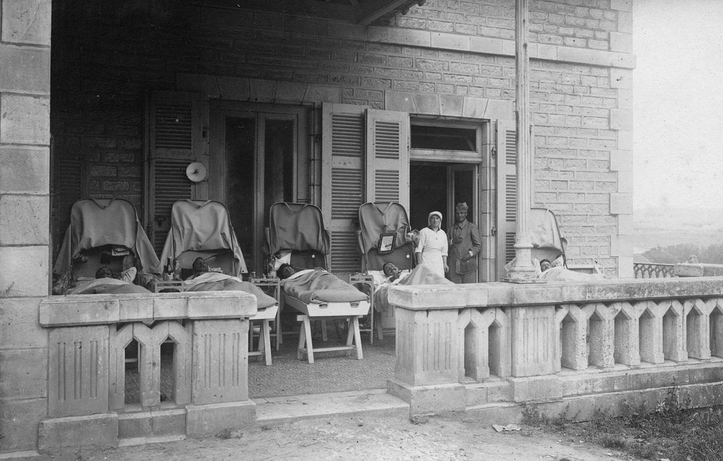 Vue de la terrasse de l'ancien bâtiment des cuisines occupée par les malades installés sur des gouttières, 1916-1922.