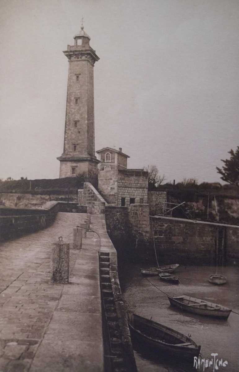Le phare et l'ancienne maison-phare vus depuis la jetée du port vers 1930.