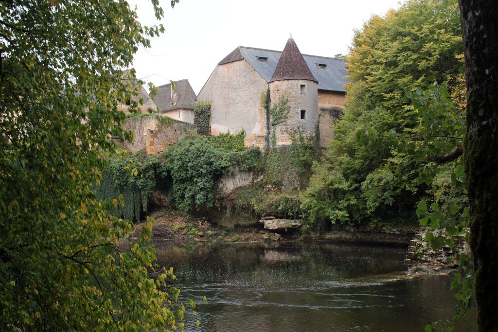 Vue du château (tour nord-est, grange-étable) au nord-est, depuis la rive gauche de la Vézère, avec les vestiges de l'écluse de Losse, à droite.
