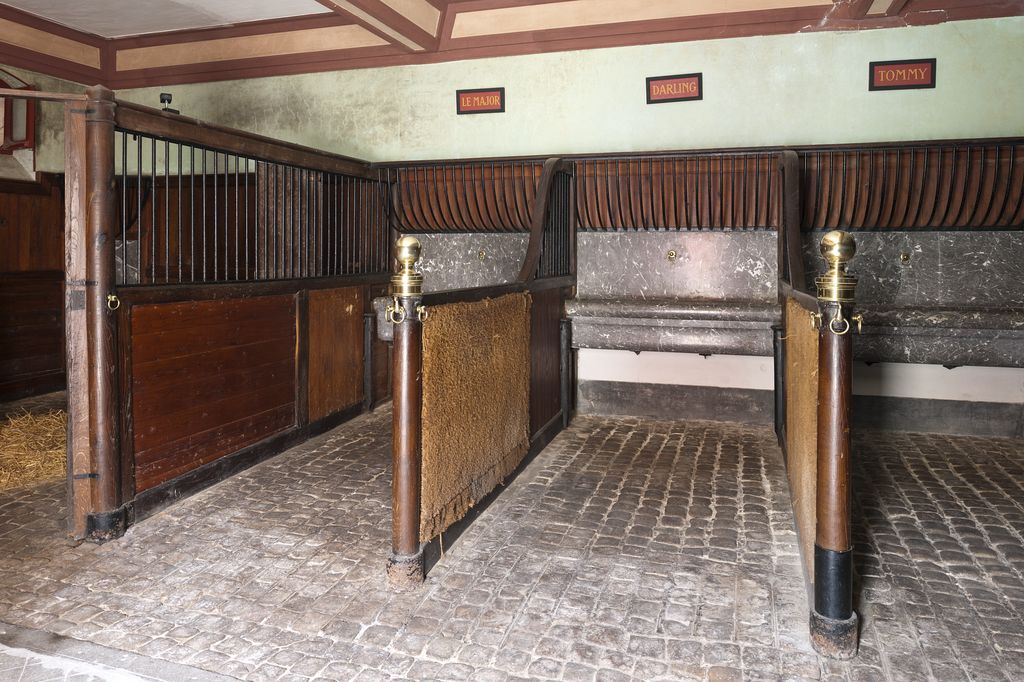 Vue intérieure : détail des stalles et des abreuvoirs.