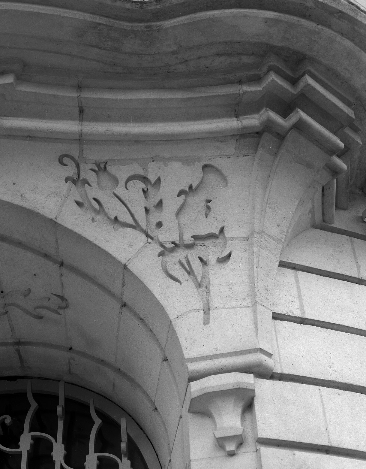 Détail des cul-de-lampes supportant le balcon du 1er étage, avec leurs écoinçons ornés de motifs floraux sculptés en creux.
