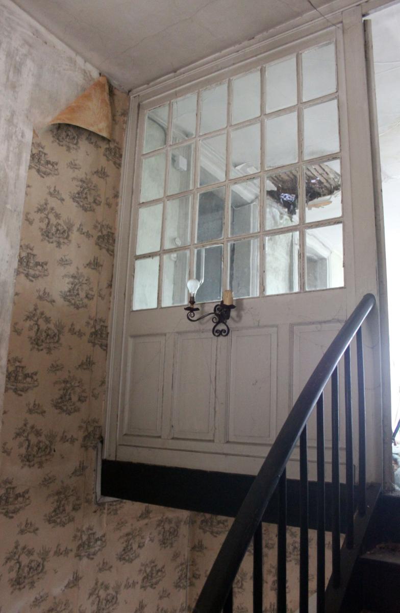 Détail de la cage de l'escalier à l'arrivée à l'étage d'attique : cloison en bois vitrée.