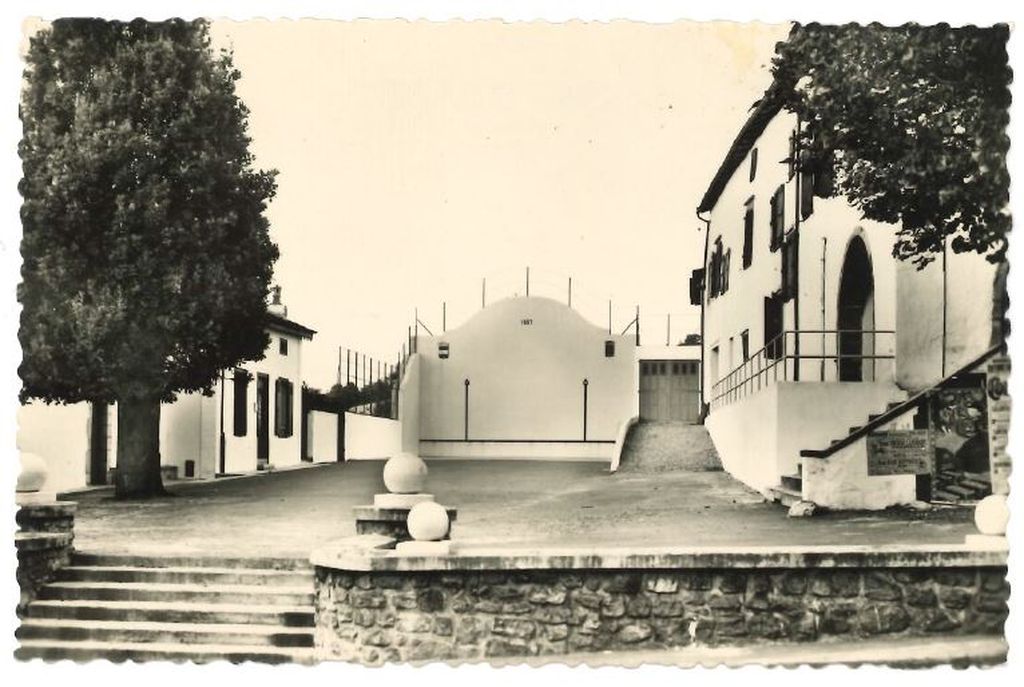 Carte postale d'une vue de la place du fronton dans les années 1960.