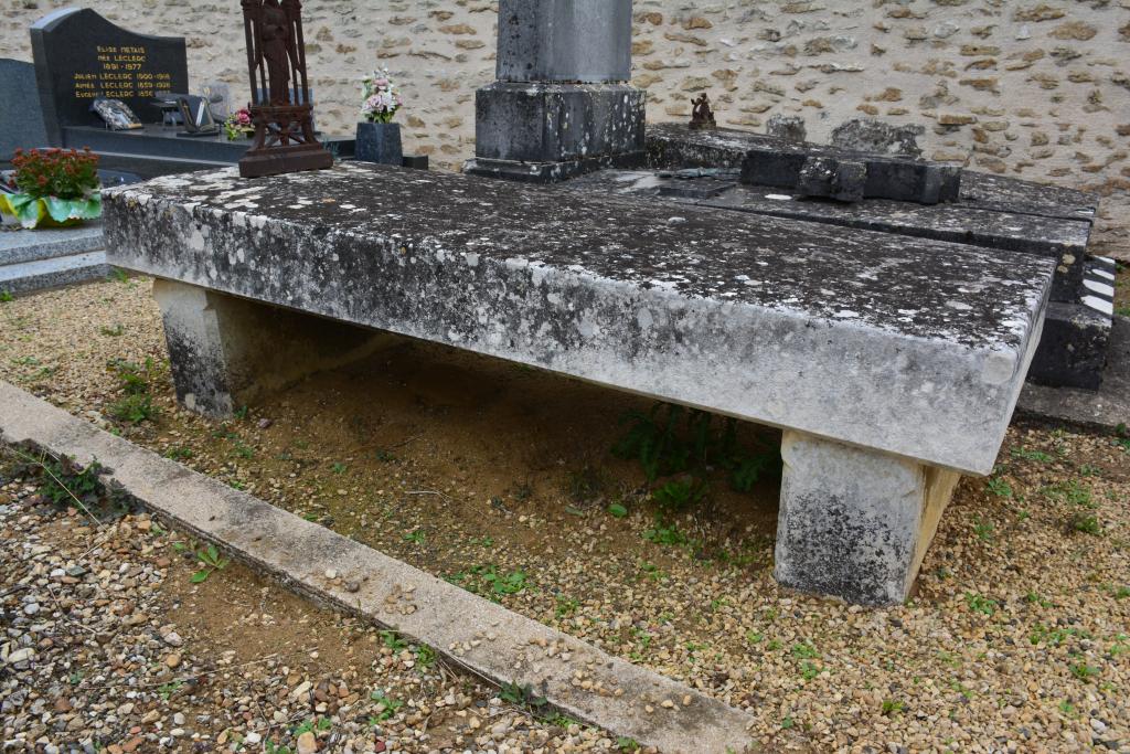 Tombeau anonyme de type sarcophage sur pieds avec croix en fonte.