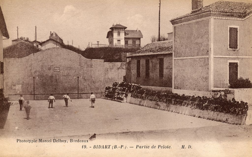 Match de pelote basque avec spectateurs sur les gradins est, 1er quart du 20e siècle.