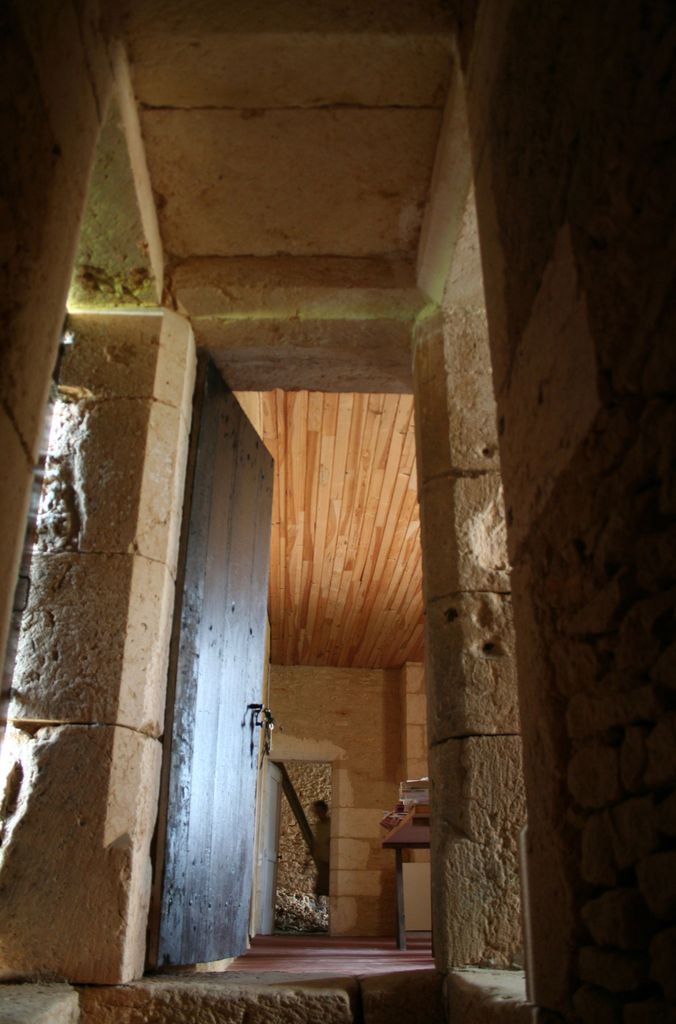 Débouché de l'escalier droit au premier étage du châtelet d'entrée : porte d'entrée dans la pièce principale située au-dessus du passage traversant.